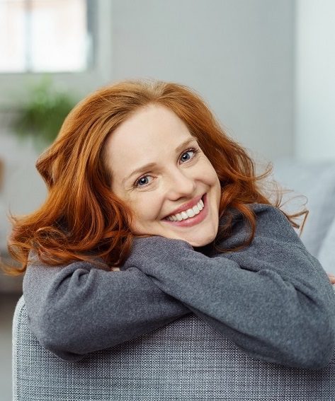 lächelnde frau liegt auf dem sofa