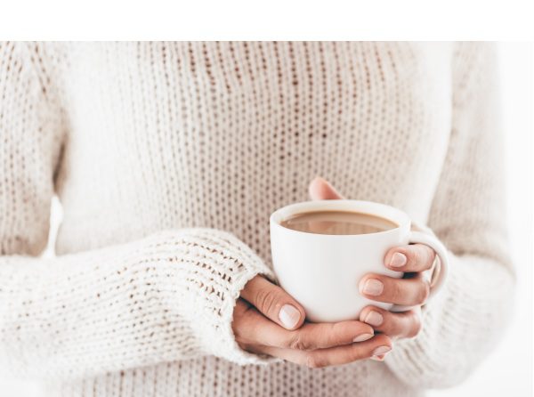 Warming cup of coffee in the hands of women
