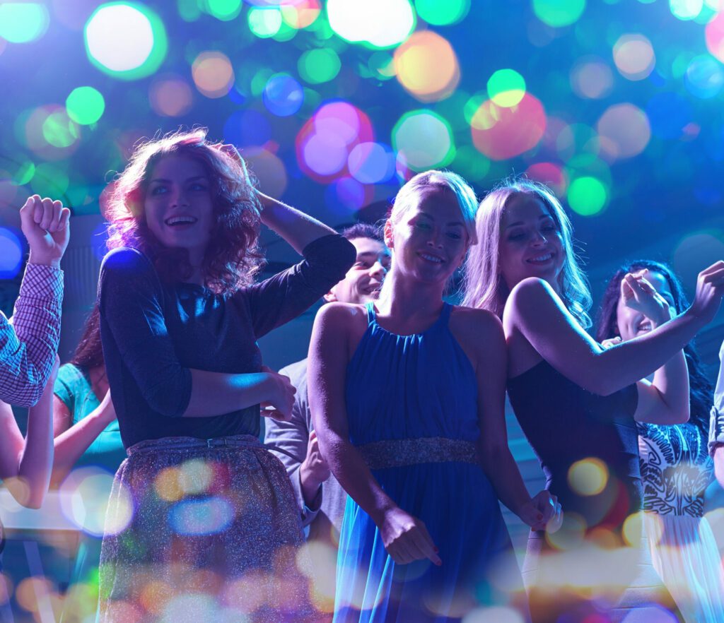 Group Of Happy Friends Dancing In Night Club