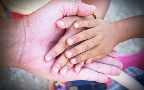Hand of an elderly holding hand of younger