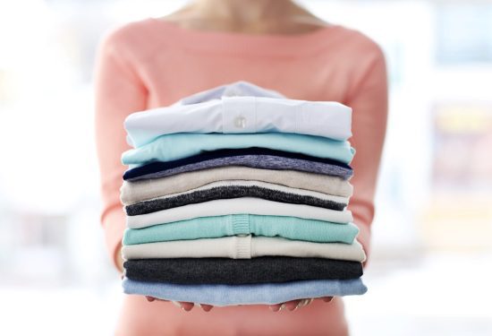 Woman Hold Clothes Pile, Close Up