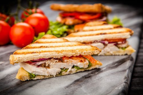 Grilled chicken sandwich with yellow cheese and vegetables