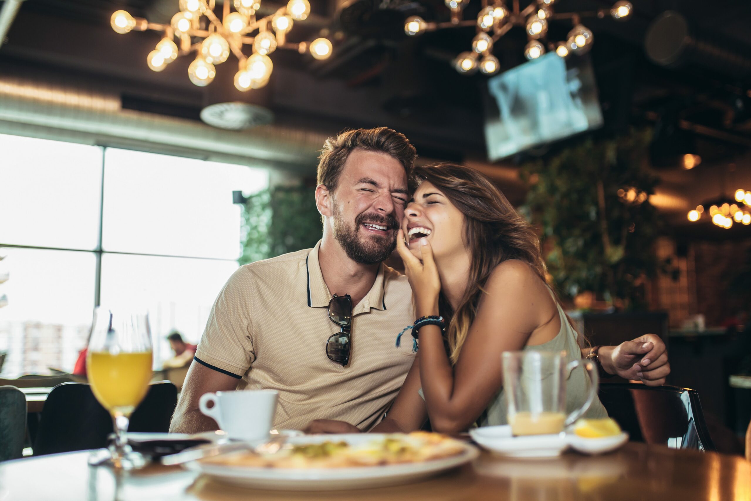 Young happy couple eating pizza in a restaurant gu10